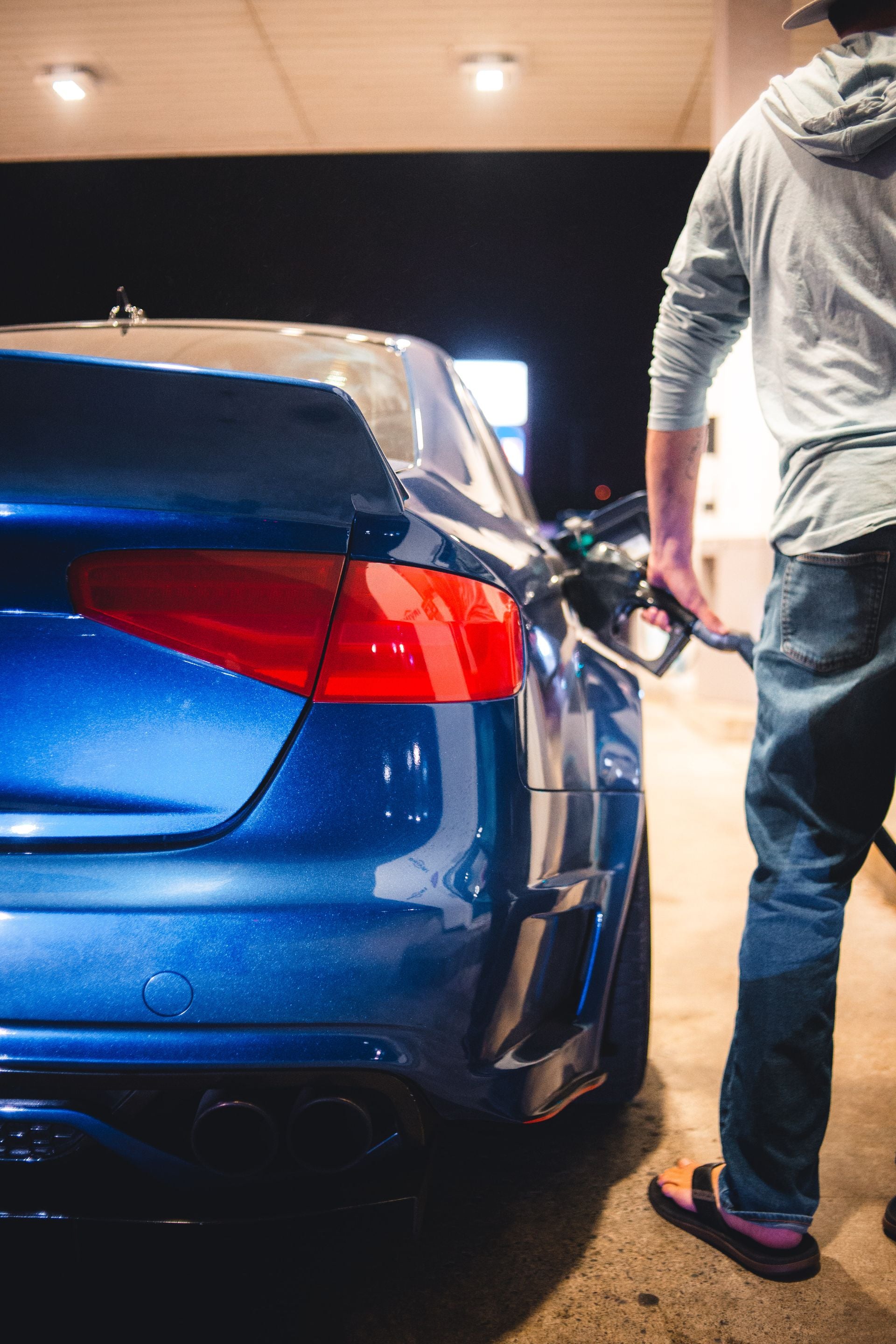 Blaues Fahrzeug beim Betanken an einer Tankstelle