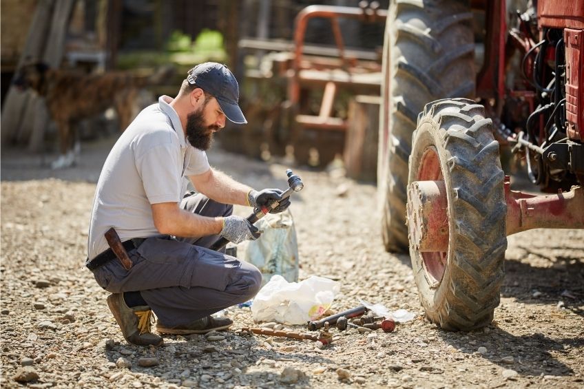 Mechaniker bei Wartungsarbeiten an einem Traktor
